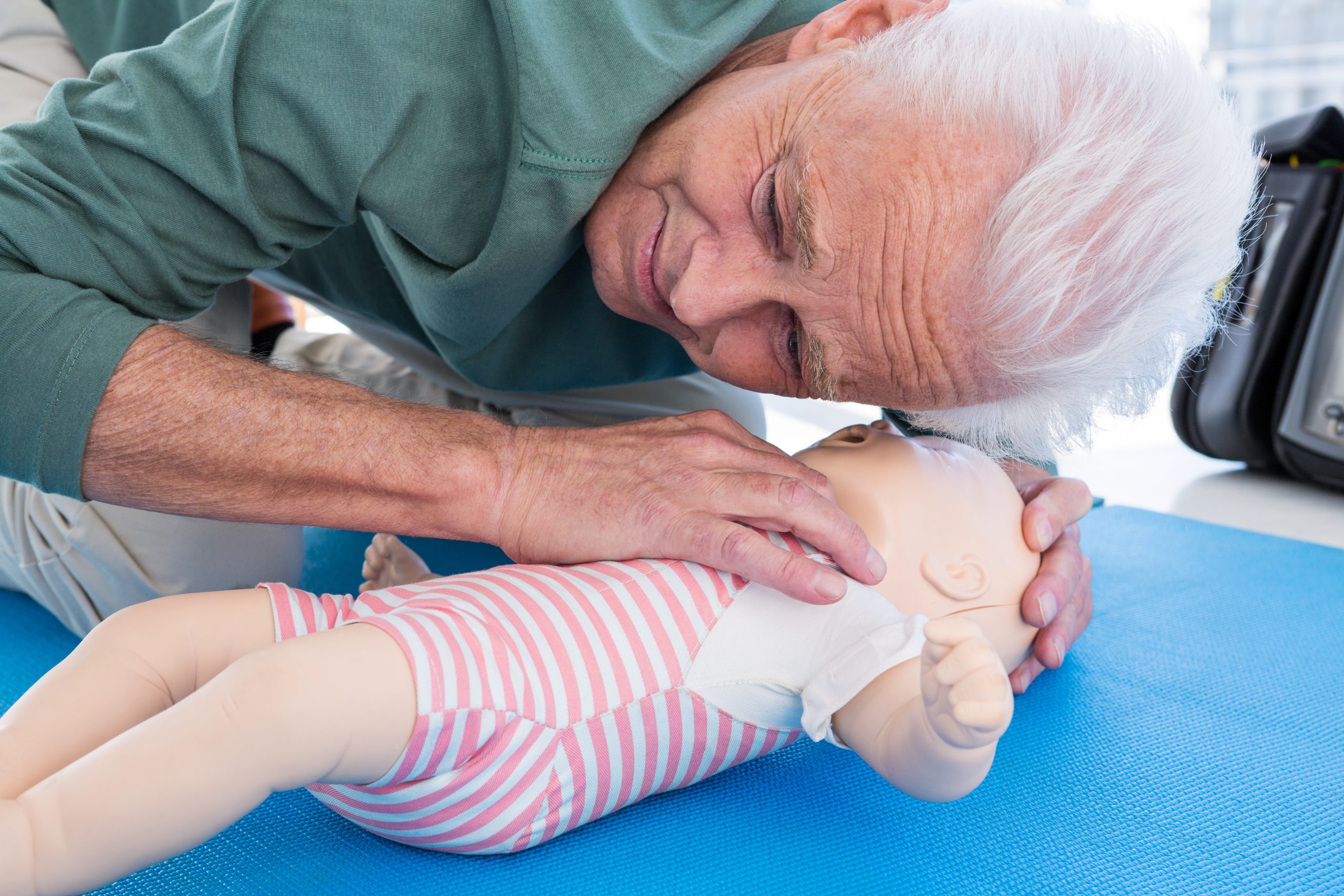 Paramedic practicing resuscitation on dummy in clinic